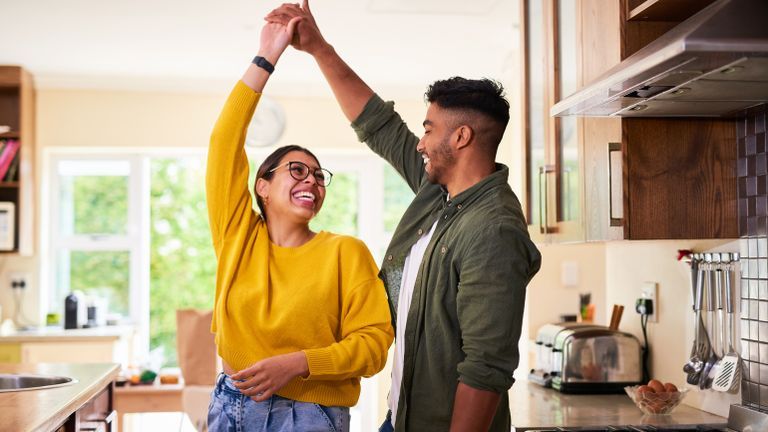 Newlywed couple dancing in their kitchen