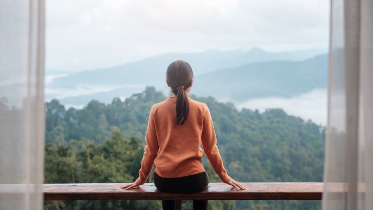 Woman sitting and overlooking mountains to celebrate lent