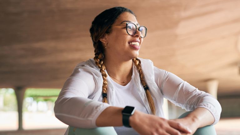 Smiling woman in workout clothes does her exercise bible habits