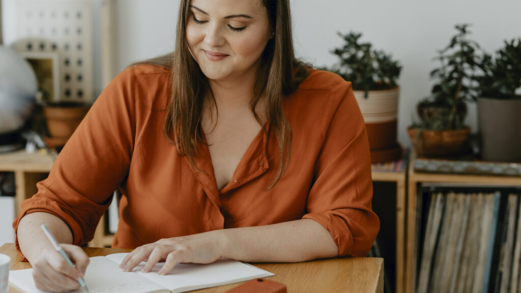 Woman using a journal to track her daily positive habits