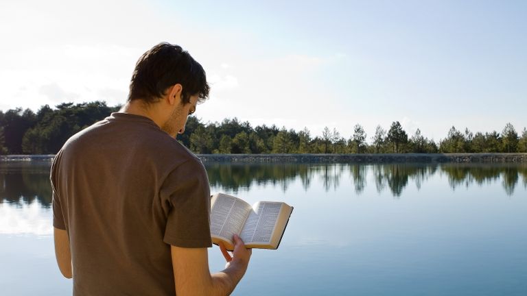 Man reading a devotional outside for Lent